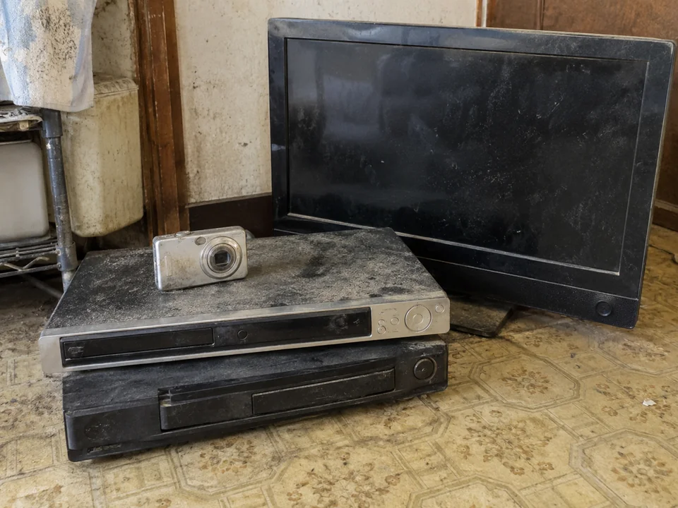 まとめて置かれた古いテレビ、録画機、カメラ